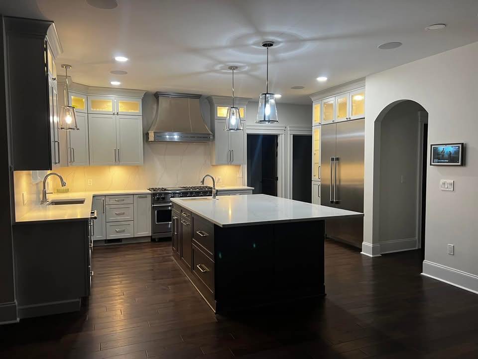 Modern kitchen remodel with large island and dark hardwood floors by Crockett Construction