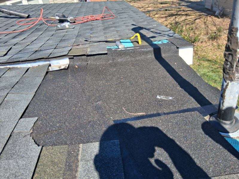 Roof repair in progress with hammer and tools by Crockett Construction